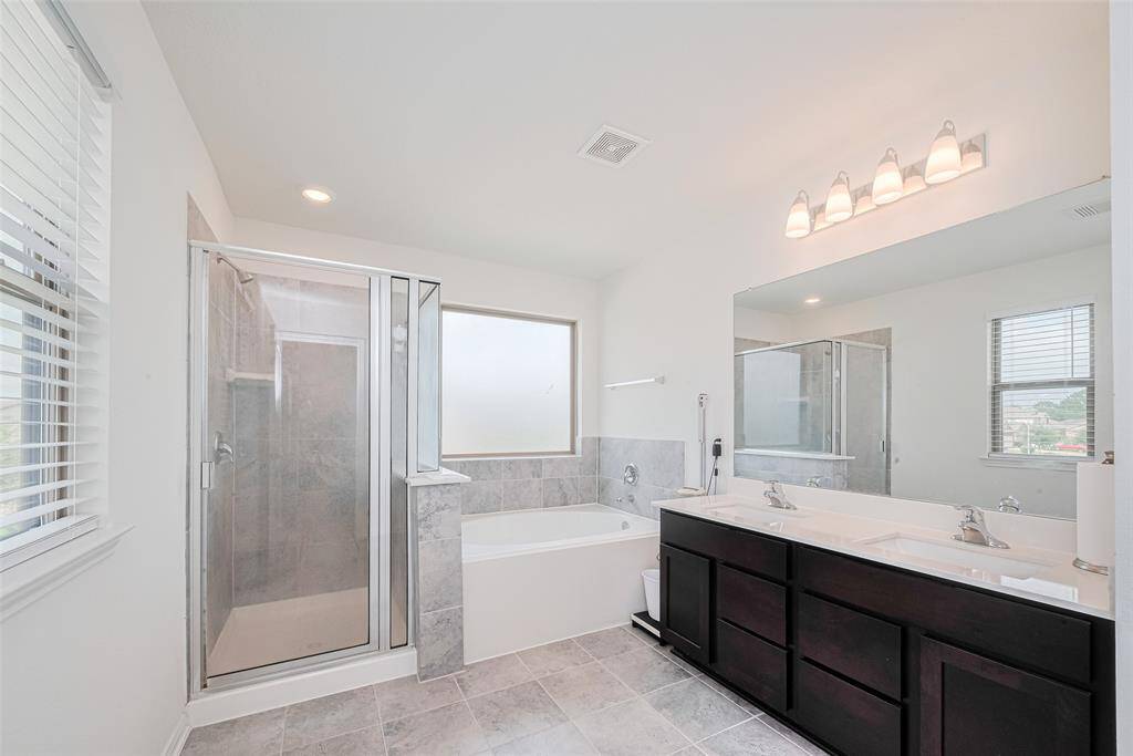 This large light-filled ensuite with three windows offers Dual Sinks, a Large Vanity, Separate Shower, and a Garden Tub, and Separate Area for the Toilet.