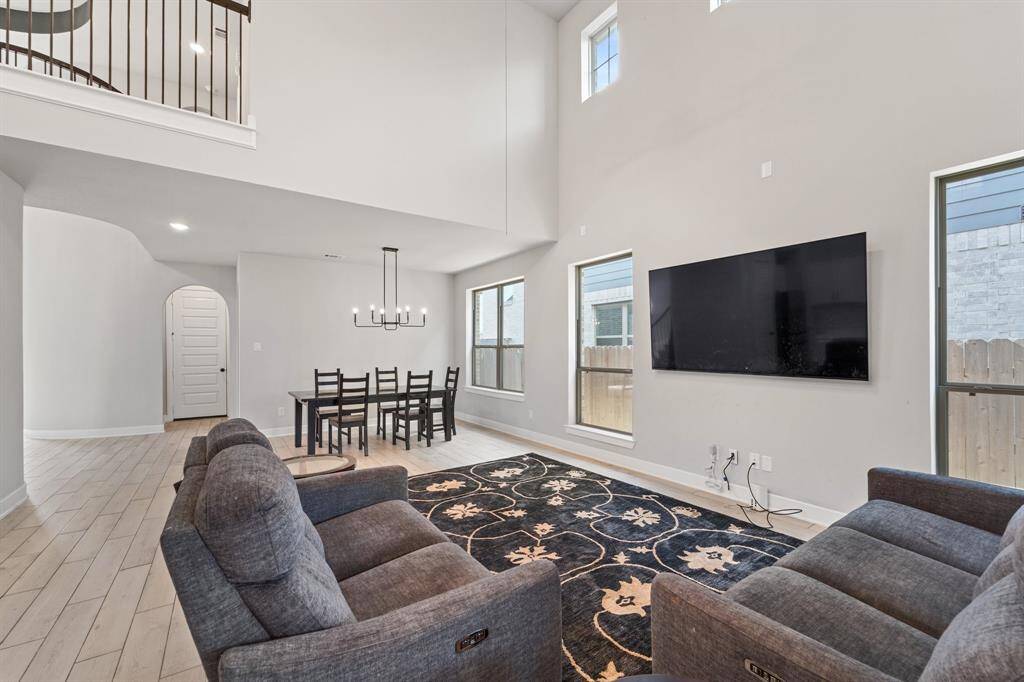 Family room with ample seating space, wall of windows, and neutral tones.