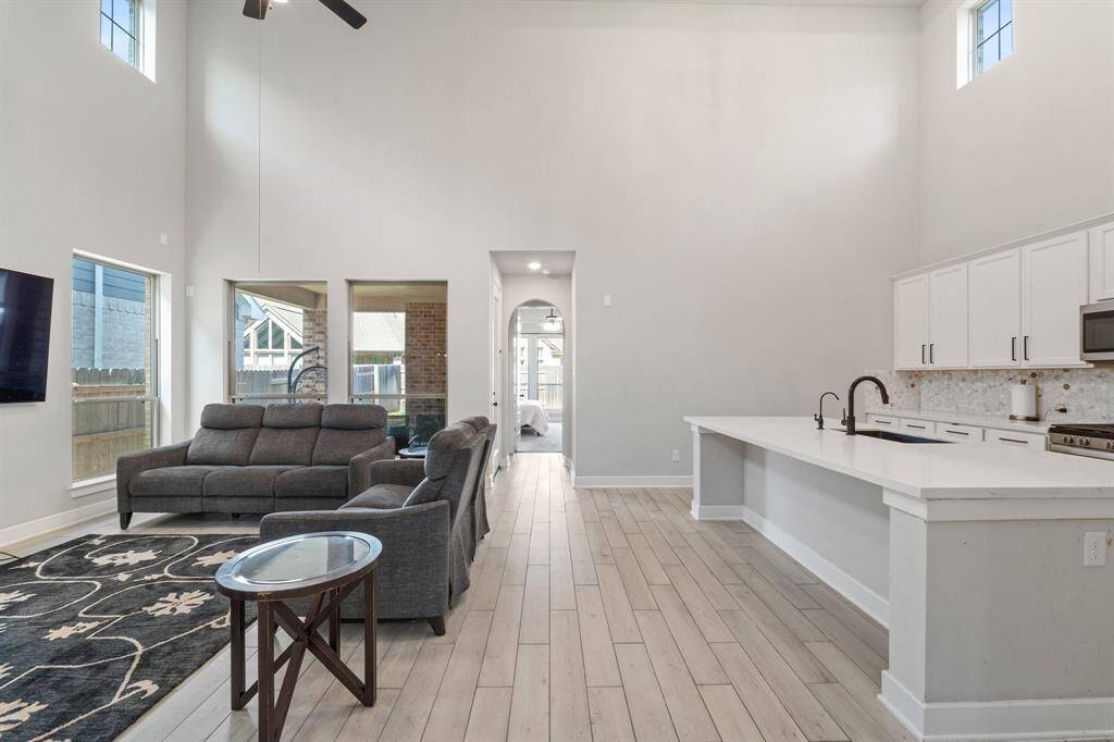 Living and kitchen area with continuous wood-look tile and modern finishes.