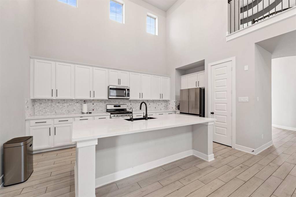 Quartz kitchen island with bar seating and stainless steel appliances.