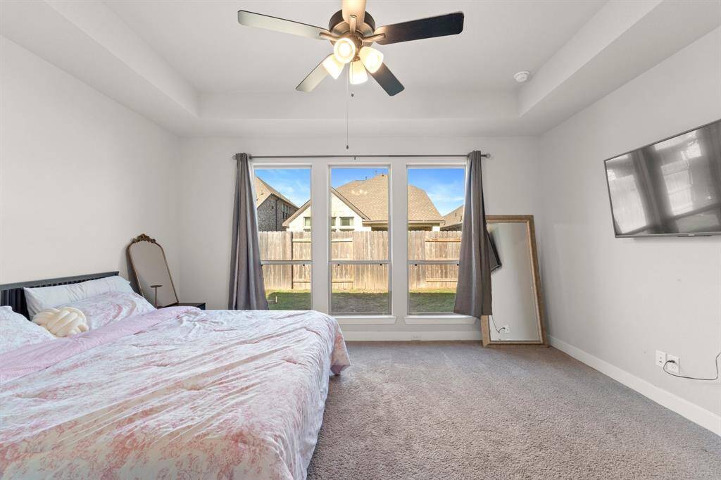 Primary bedroom with large windows, ceiling fan, and plenty of natural light.