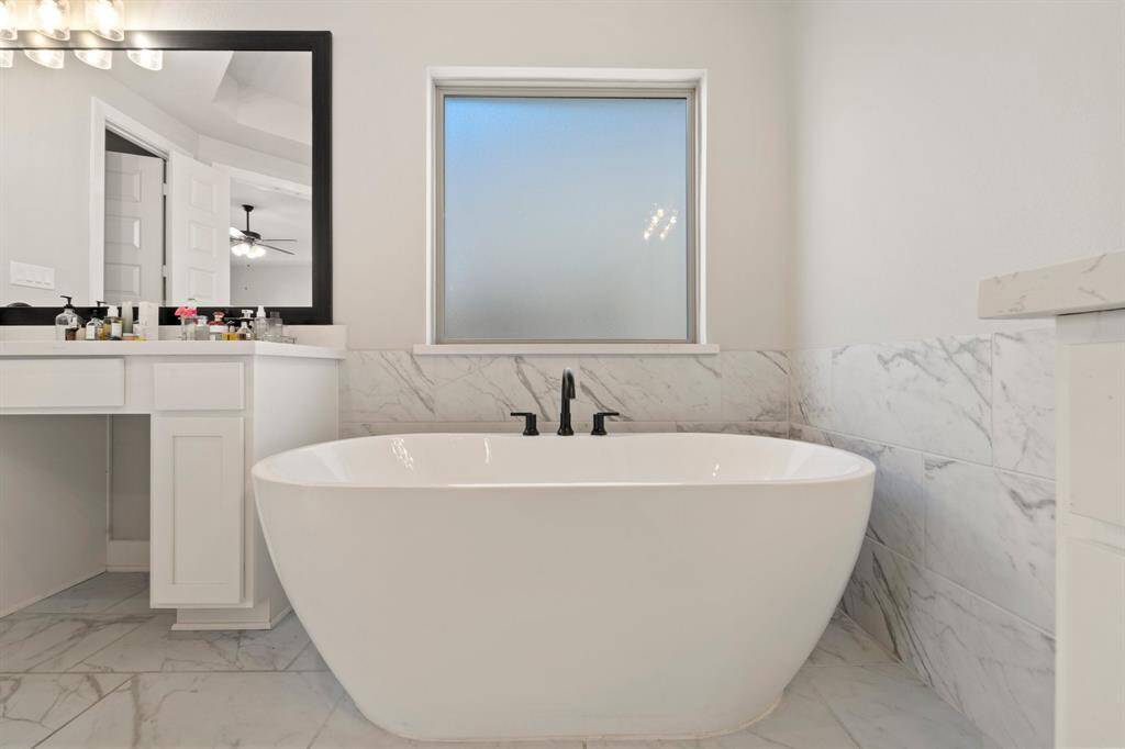 Secondary angle of primary bath with quartz counters and generous lighting.