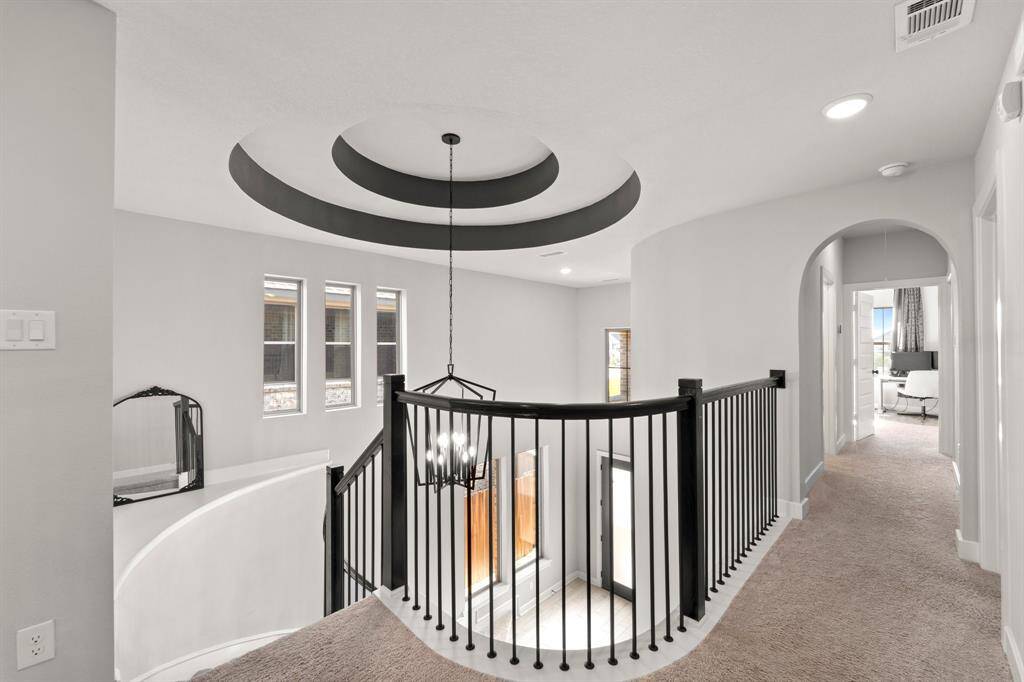 Upstairs hallway with curved landing and open sightlines to both floors.