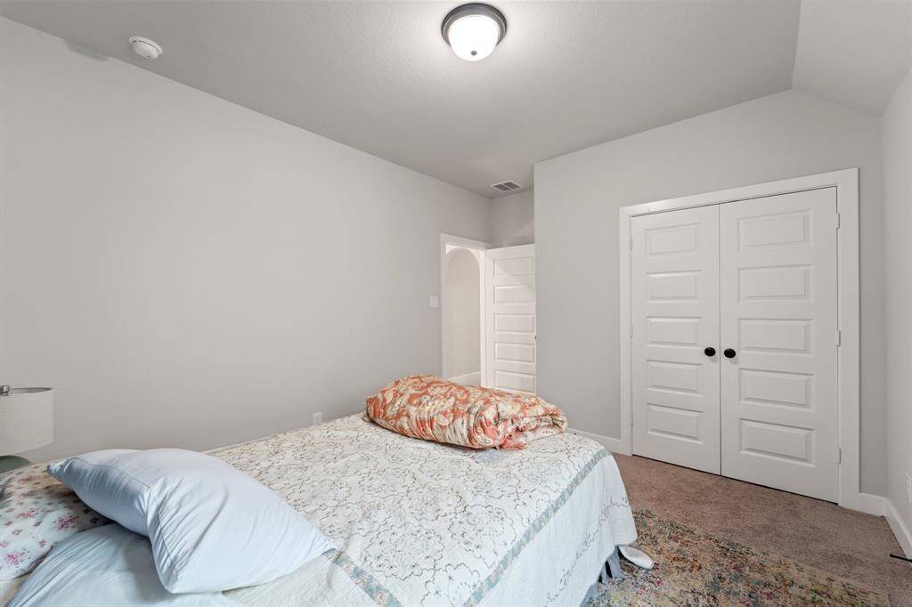 Spacious secondary bedroom with plush carpeting and neutral color palette.