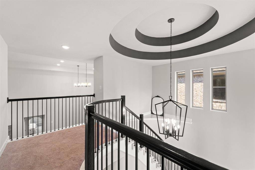 Hallway view coming out of the secondary bedrooms, highlighting flow toward the open landing and living areas below.