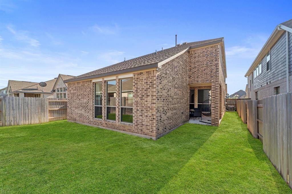 Backyard view with plenty of green space and rear elevation.