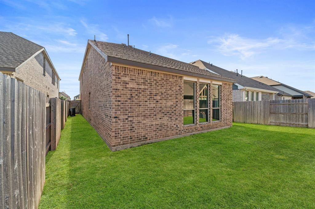 Side view of the backyard and exterior brickwork.