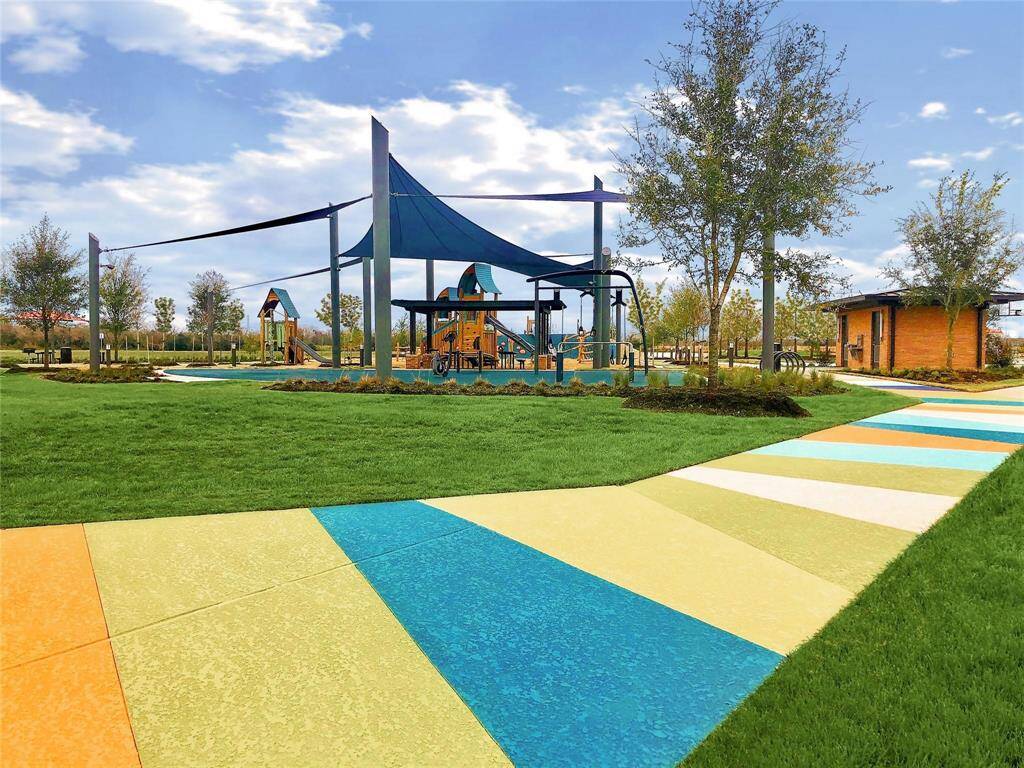 Colorful community playground with shade structures and walking paths.