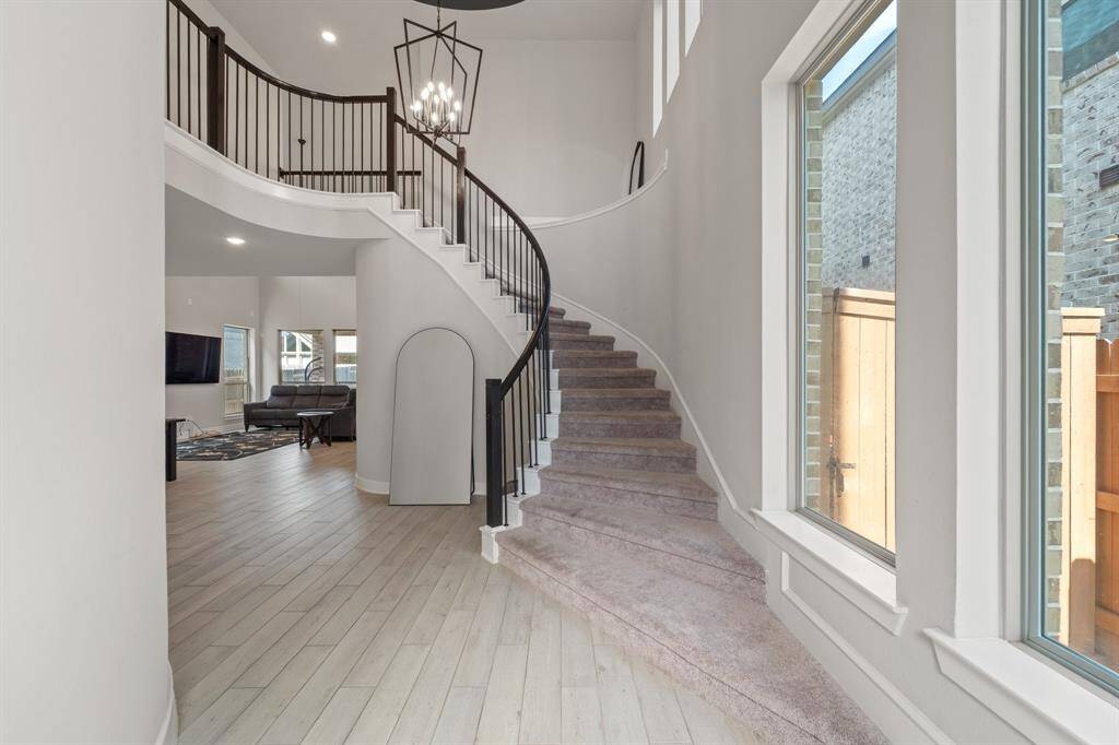 Grand entry with curved staircase and soaring ceilings—immediate wow factor.