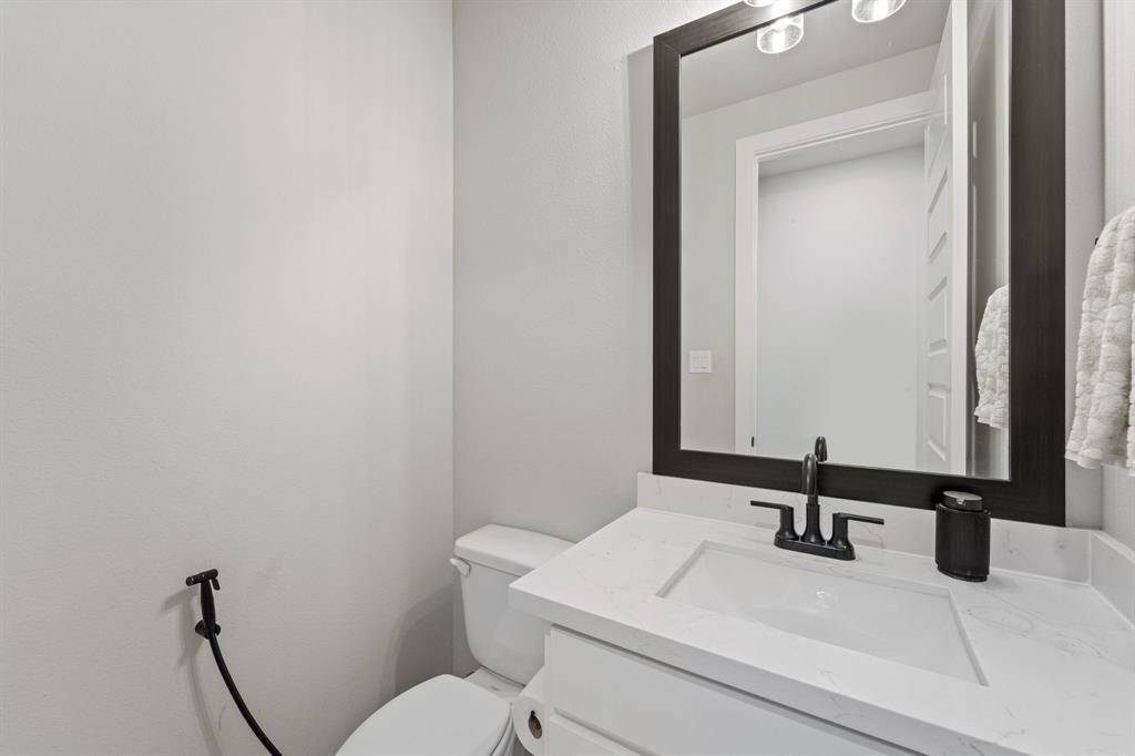 Stylish powder bath with framed mirror and pedestal sink.