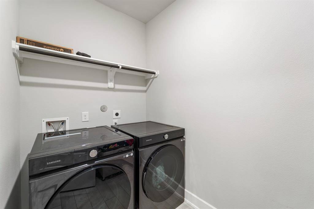 Spacious laundry room with built-in shelving and washer/dryer hookups.