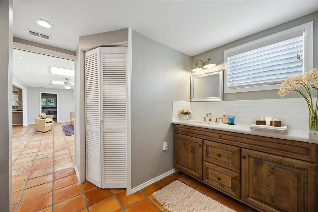 The primary bathroom has a separate shower and is en suite the primary bedroom and back sunroom. There are two walk in closets to serve the primary bedroom, one is pictured.