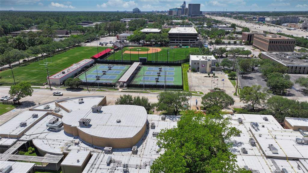 Here you see the rooftop of Spring Branch Middle School and the tennis courts/baseball field of Memorial Highschool, with the highschool being across the street in the background is Memorial City, there is a mall a medical building and a hotel, amoung other things. The highway you see on the right is I10, the camera is facing West.