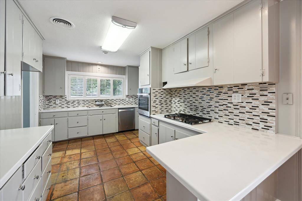 The kitchen has an abundance of natural light, serves at the center of the home, has an en suite utility room with extra pantry space and the  washer and dryer.