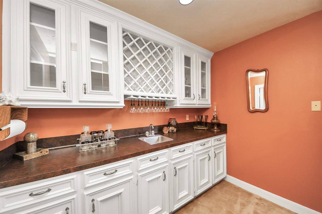 The upstairs game room includes an inset bar with wine glass holders and cabinetry, plus two spacious closets for extra storage—perfect for entertaining and organizing.