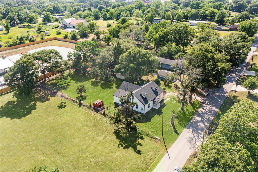 Beautiful aerial view of this oversized lot with mature trees and wide-open space.