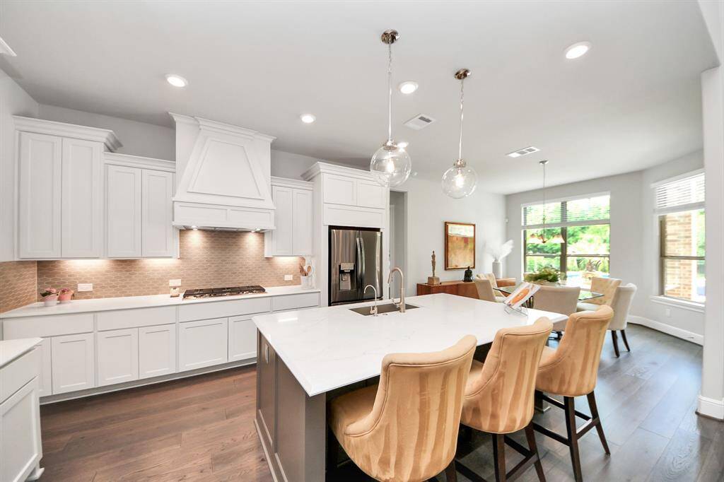 Modern kitchen with an open layout featuring a large island, sleek countertops, and stylish pendant lighting.