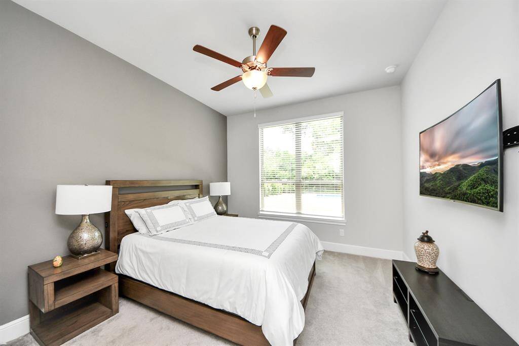 Inviting first-floor secondary bedroom with an en-suite bathroom, perfect for guests or family. It has a stunning backyard and pool views.