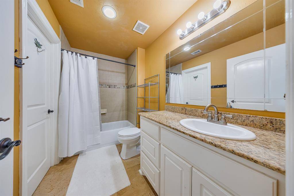 Bathroom #3 features ample storage and a large mirror, combining functionality with comfort for everyday use.