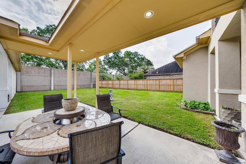 Covered patio deck provides a shaded outdoor space, ideal for relaxing, dining, or entertaining year-round.