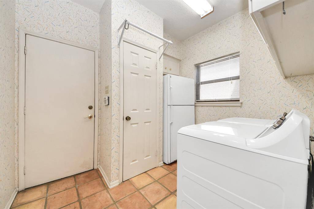 Spacious laundry with storage closet and space for additional fridge or freezer.