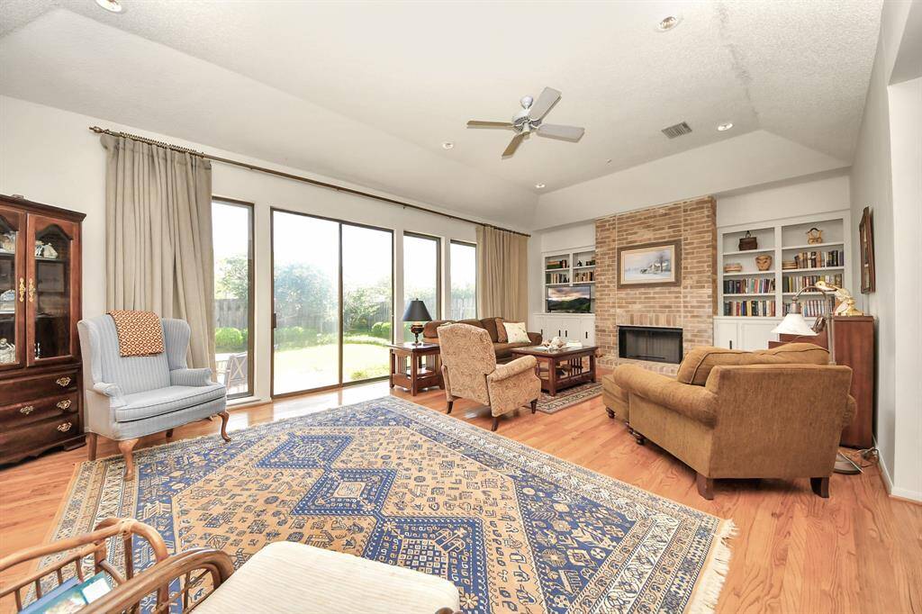 Oversized living room features gas fireplace flanked by custom built shelves and cabinets.