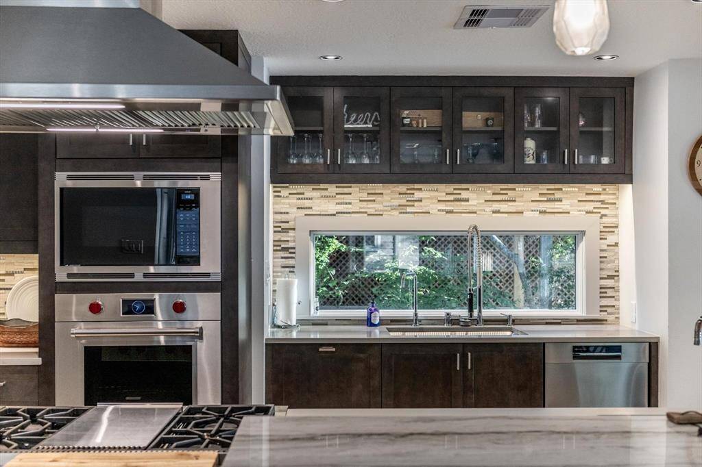 This chef-inspired kitchen showcases premium Wolf-Subzero & Bosch appliances, and a striking backsplash with window over one of the 2 sinks to let the outside in!