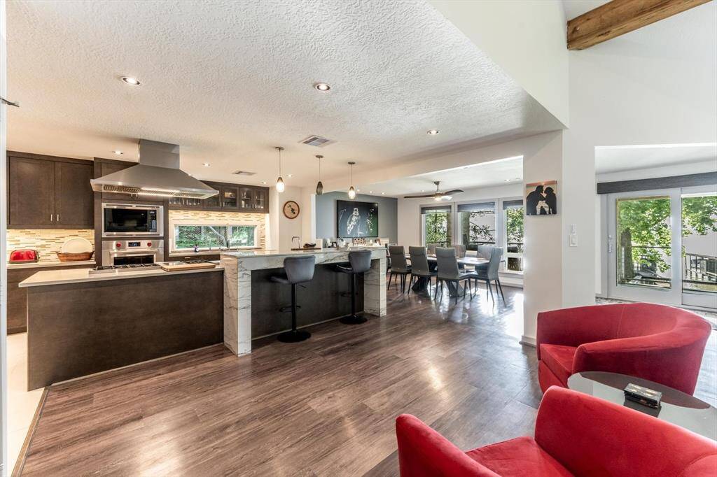 Clean lines, rich flooring, and abundant natural light creates an inviting atmosphere perfect for cozy nights in or lively gatherings.