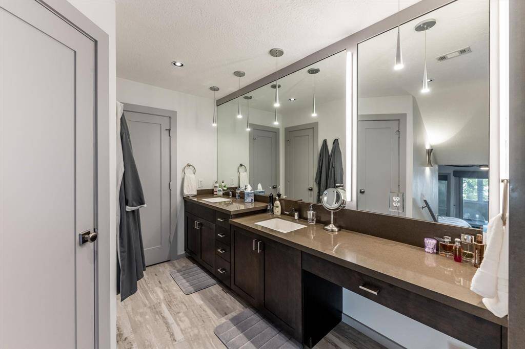 Modern, sleek, and spa-inspired—this primary bath features double sinks, quartzite countertops, chic lighting, and a built-in vanity designed for everyday luxury.