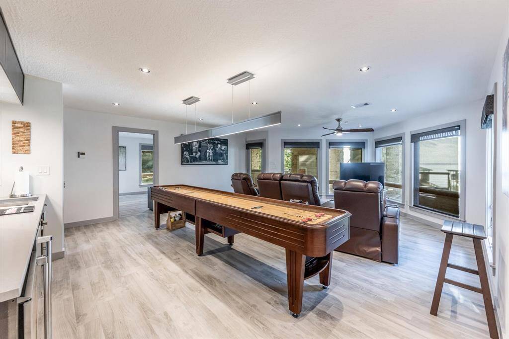 Game night just got an upgrade—this light-filled retreat comes ready with a shuffleboard table, windows that over look the lake, a  wet bar, and plush recliners for the ultimate hangout....for movie nights or amazing views.