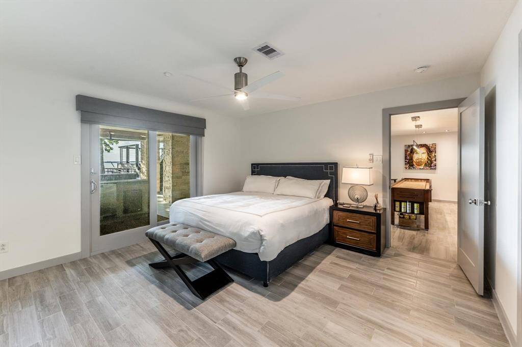 Tucked just off the game room, this private guest suite offers restful vibes, sleek tile floors, and direct access to the patio for a peaceful morning escape.