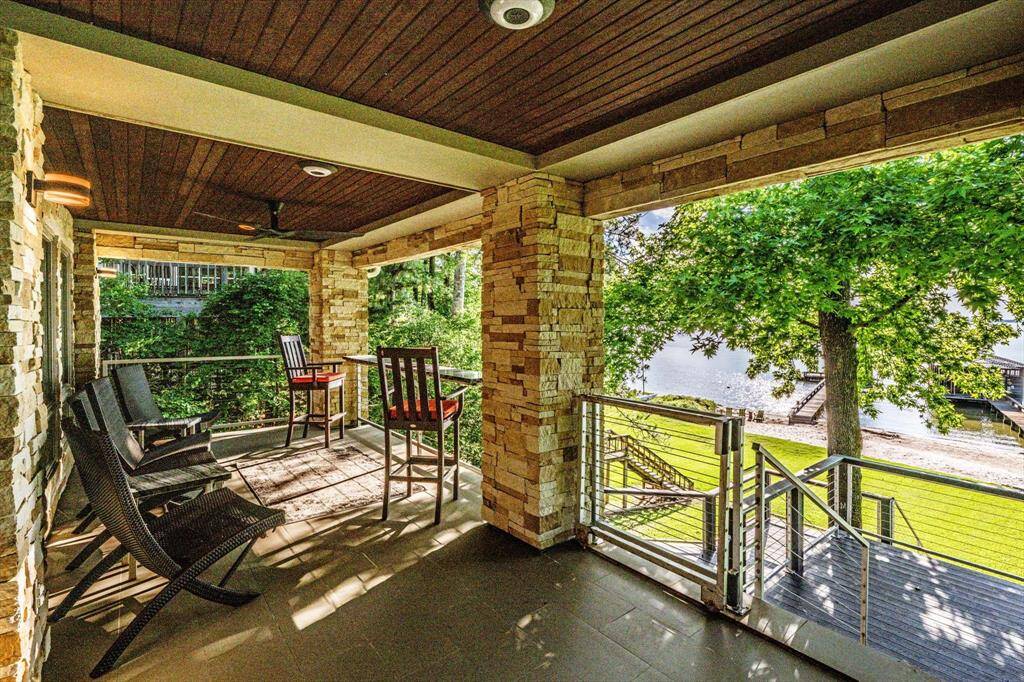 Framed in stone and shade, this covered terrace is your front-row seat to the lake. Where timeless architecture meets tranquil lakefront mornings.