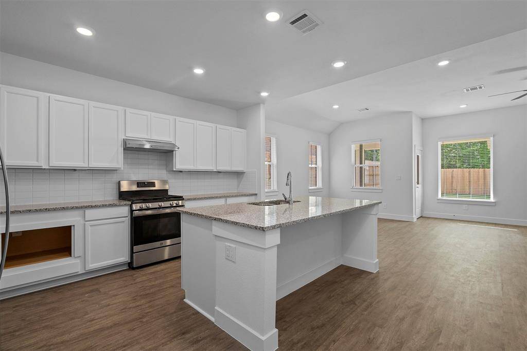 Beautiful island kitchen with granite countertops and gas cooktop!  Microwave drawer to the let of the stove!