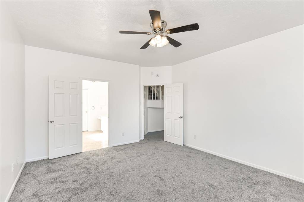 Discover this inviting bedroom featuring fresh paint, plush carpeting, and abundant natural light. The ceiling fan adds comfort, while dual doors offer easy access to adjacent areas. Ideal for a peaceful retreat.