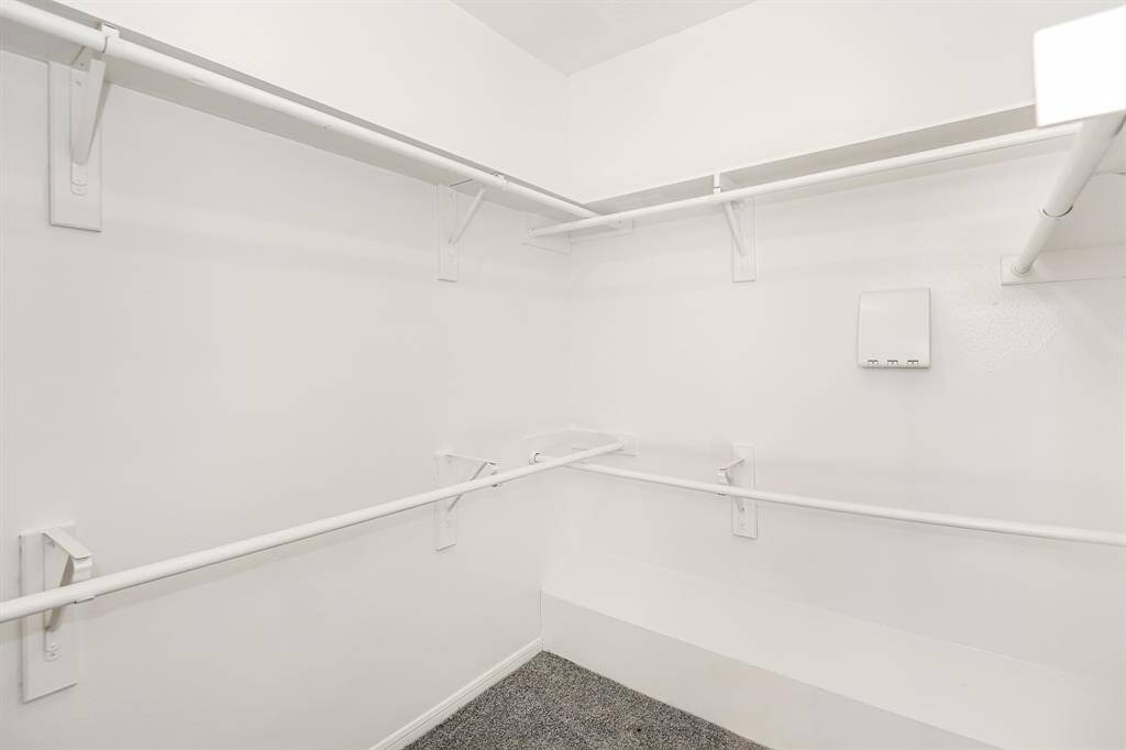 Spacious walk-in closet with ample shelving and hanging space, perfect for organizing your wardrobe effortlessly.