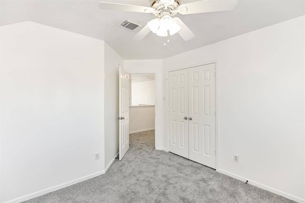 Bright and inviting room featuring fresh white walls, plush carpet, and a ceiling fan for comfort. The double doors lead to a spacious area, perfect for storage or a personal retreat. Ideal for creating your dream space.