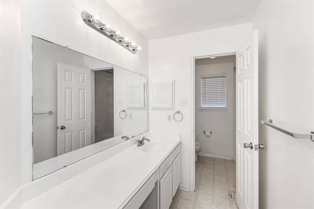 Discover a bright and inviting bathroom featuring a spacious double vanity, ample storage, and modern lighting. Perfect for your daily routine.