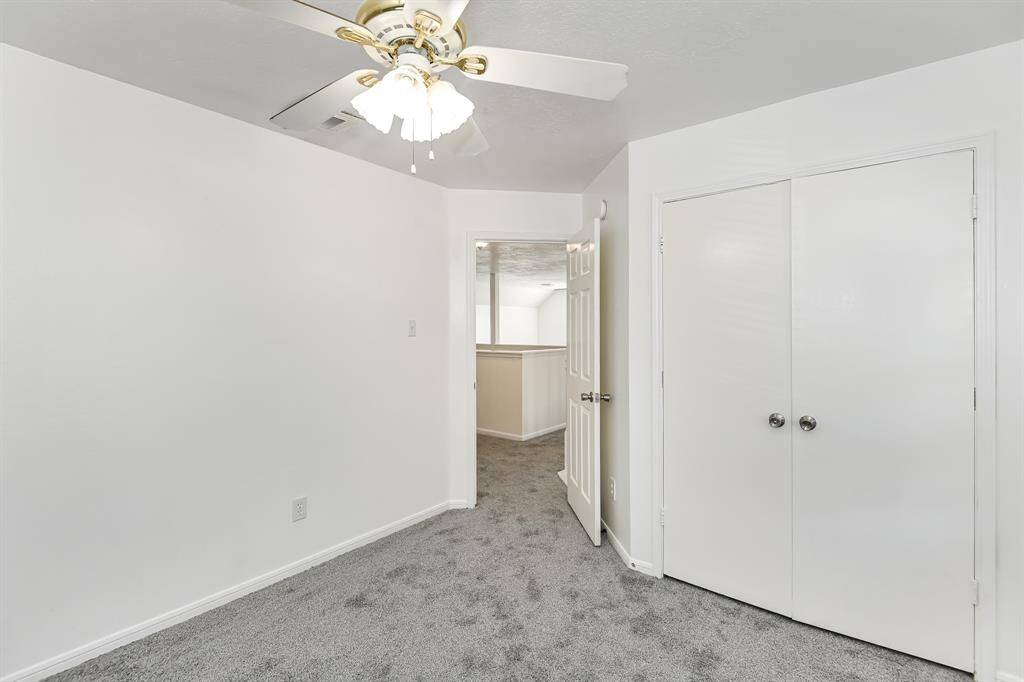 This bright, cozy room features fresh carpet, a modern ceiling fan, and ample closet space, offering comfort and functionality. Ideal for a bedroom or home office.