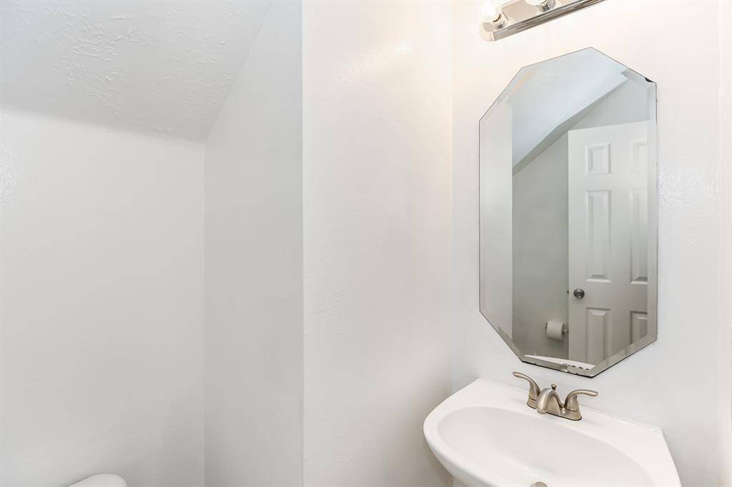 Discover a bright, modern bathroom with sleek fixtures and a stylish octagonal mirror, perfect for adding a touch of elegance to your daily routine.