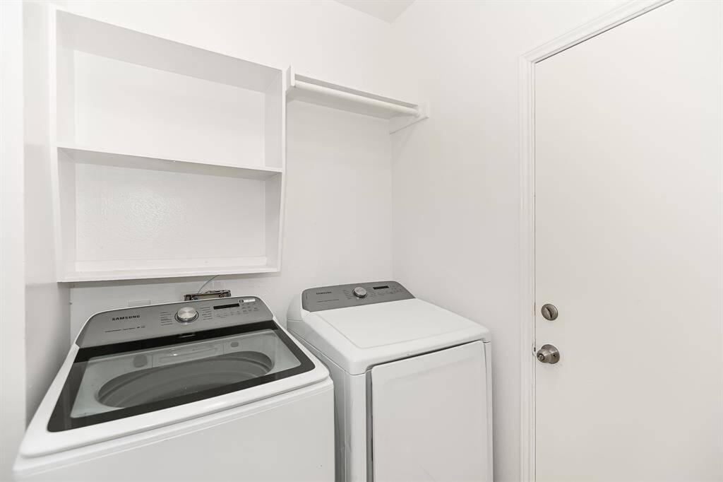 This bright laundry room features modern appliances and ample shelving for convenient storage.
