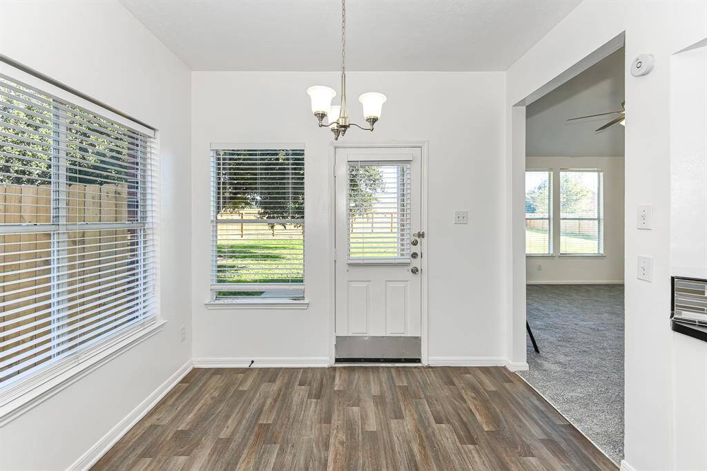 Bright and inviting space with large windows overlooking a lush backyard. The open layout seamlessly connects indoor and outdoor living, perfect for enjoying natural light and serene views.