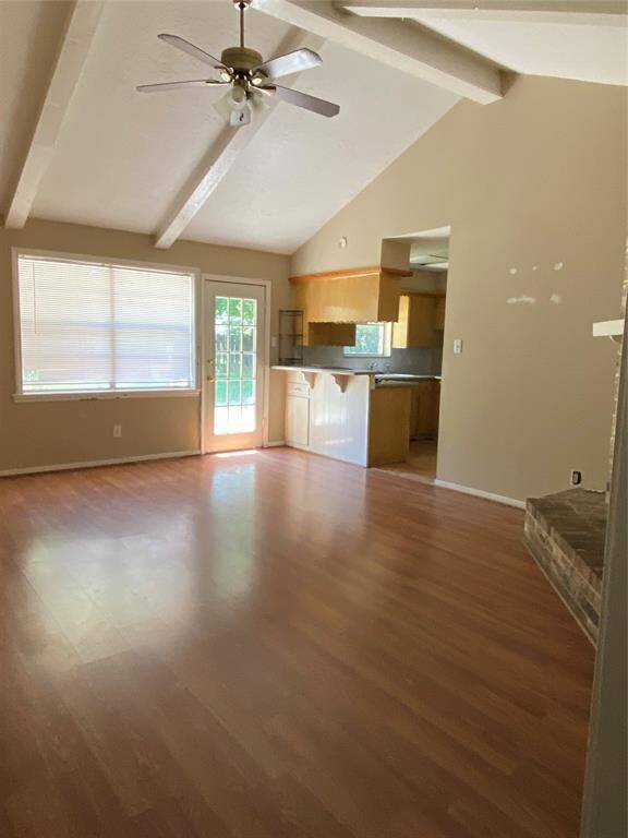 One open living area, high ceiling, ceiling fan, laminate flooring