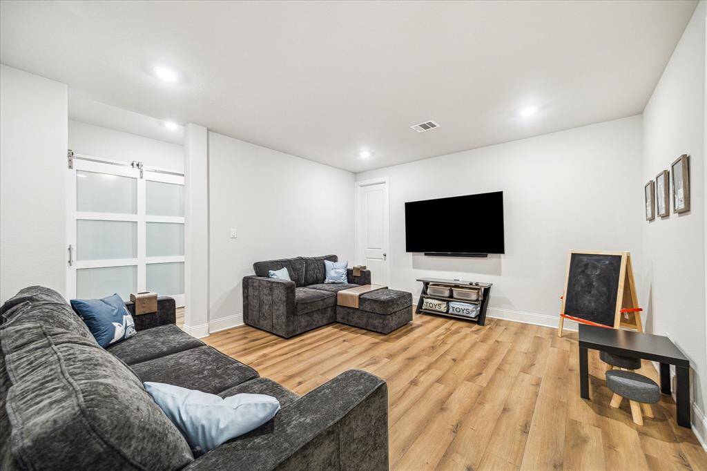 Flex room, used here as a family den, kids play space. Sellers added storage closet option seen in left corner.  Two additional secondary bedrooms and one bathroom located on this side of the home.