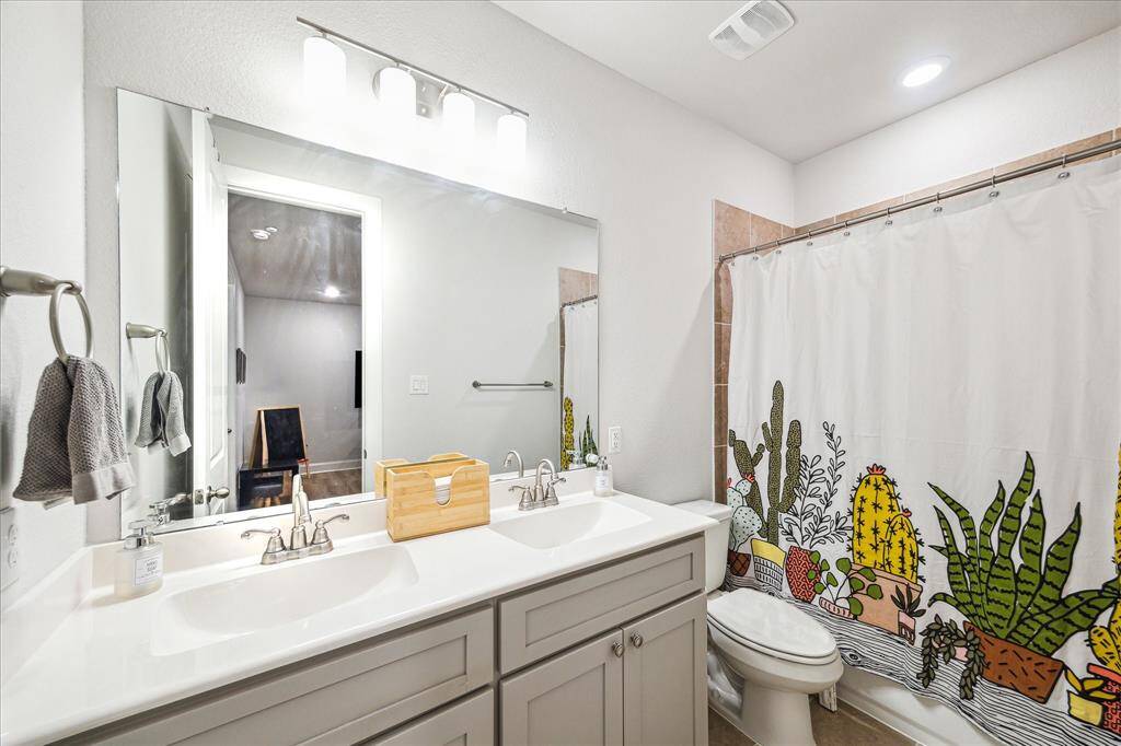 Secondary bath wit upgraded vanity to accommodate two sinks.  Tub/shower combo with full tile surround.