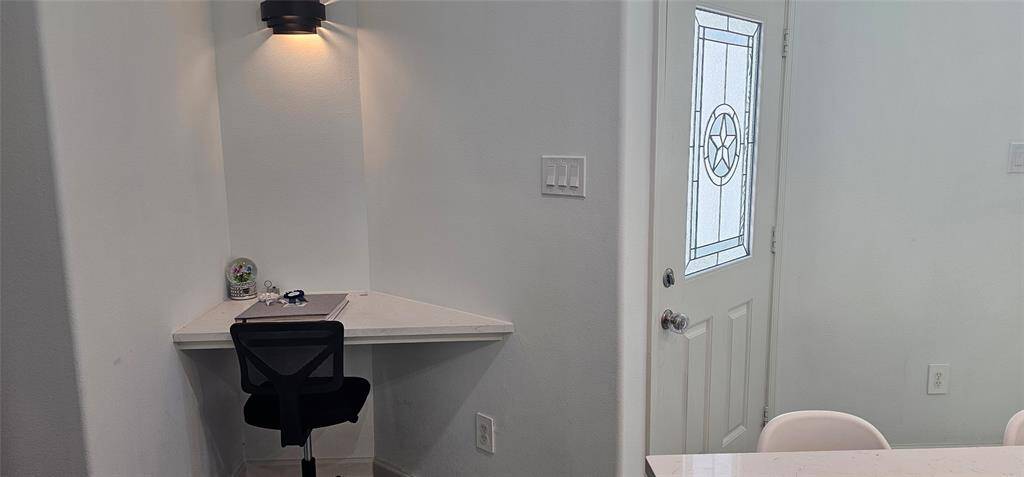 This home offers a small, cozy corner for your home management center or possibly a functional space for work or study. Your computer space is well-lit with a wall-mounted light.