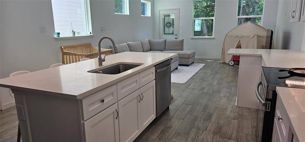 This bright, open-concept space features a kitchen with a large island and sleek quartz countertops. The kitchen space is open to the living area. Great for entertaining or just having fun with the family.