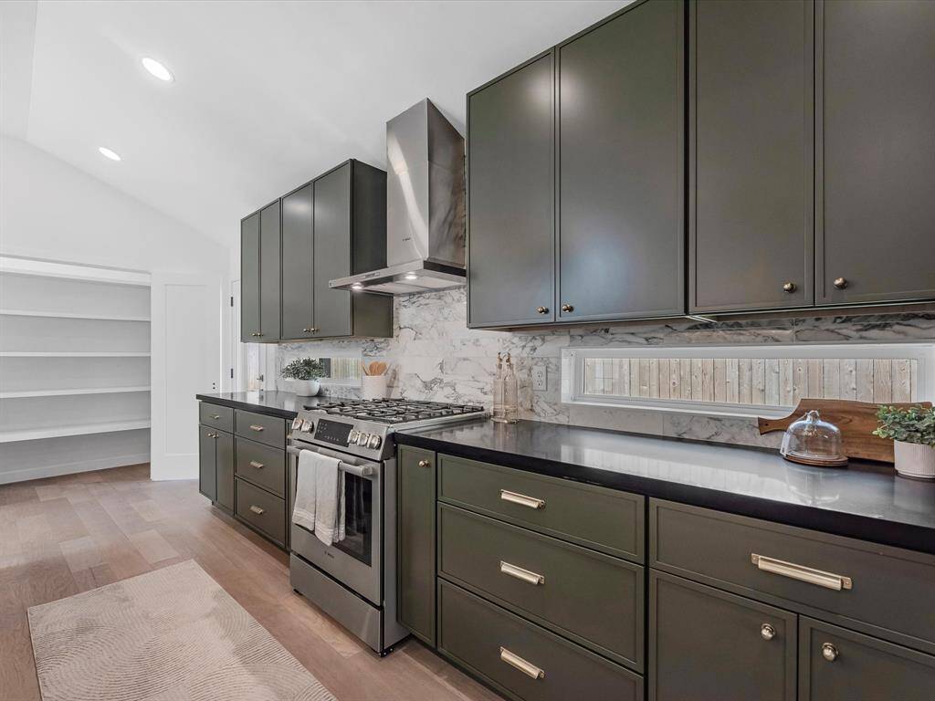 Trending skinny shaker self-close cabinets with custom windows in the backsplash to bring in more natural light