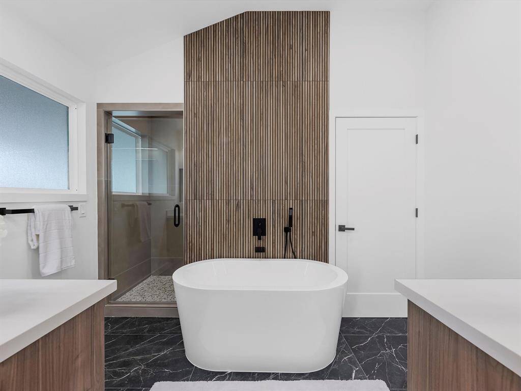 Primary bathroom with dramatic bathtub backsplash wall, double sink and shower
