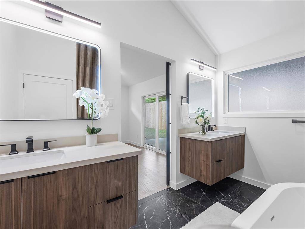Primary bathroom with LED mirrors and double sink.