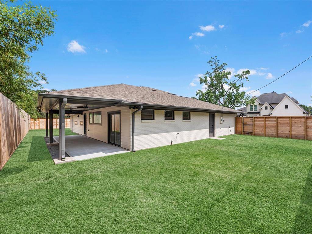 View of the back yard and side yard with extended covered porch.